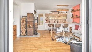 A modern kitchen with wooden bar stools, a central island, and a rustic wooden bench. - The Mountain Suite Top  11 - Tauplitz Residences (Tauplitz)