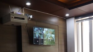 Ein modernes Wohnzimmer mit einer Ledersofa, einem Wand-Fernseher und einem Fenster, das für natürliches Licht sorgt.