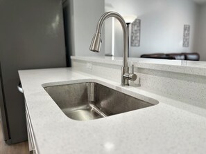 Una cocina moderna con un lavamanos y grifo de acero inoxidable.
