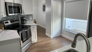 A modern kitchen with stainless steel appliances, a built-in microwave, and a coffee maker.