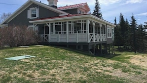 A two-story house with a covered porch and a red roof.