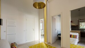 A bedroom with a bed, a yellow patterned rug, and a white door.