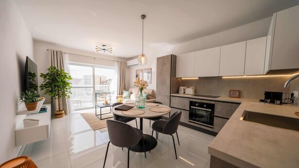 Una cocina moderna con comedor, un ventanal y vistas a la ciudad.