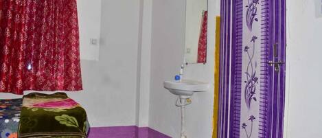 A room with a bed, a sink, and a door with floral design.