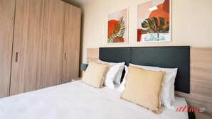 Une chambre d’hôtel avec un grand lit, deux oreillers, une tête de lit et une armoire.