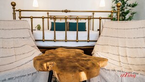Une chambre à coucher avec un lit, des tables de chevet et une plante suspendue.