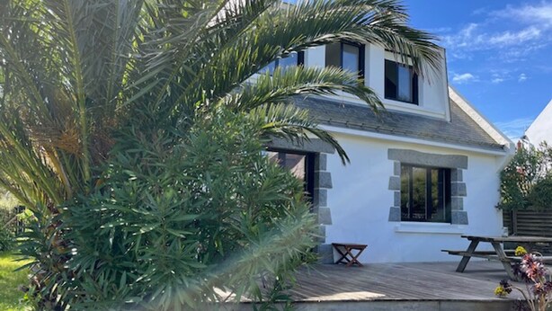 A modern two-story house with a wooden deck, a small outdoor table, and a picnic table. - Family house near Groix beach, garden and garage (Groix)
