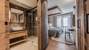 Une salle de bain moderne avec un grand miroir, un meuble-lavabo en bois et une cabine de douche en verre.