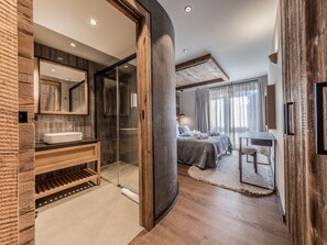 Une salle de bain moderne avec un grand miroir, un meuble-lavabo en bois et une cabine de douche en verre.