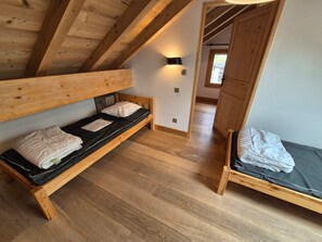 A room with two wooden bunk beds, a small cabinet, and a wall-mounted light fixture. - Bright duplex apt 8 people, 250m from slopes, pets allowed (Les Deux Alpes)