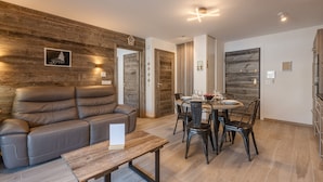 Una sala moderna con sofá, mesa de comedor y sillas.