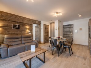 Ein modernes Wohnzimmer mit einer Couch, einem Esstisch und Stühlen.