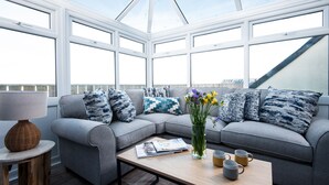A modern living room with a grey sofa, a wooden coffee table, and a lamp.