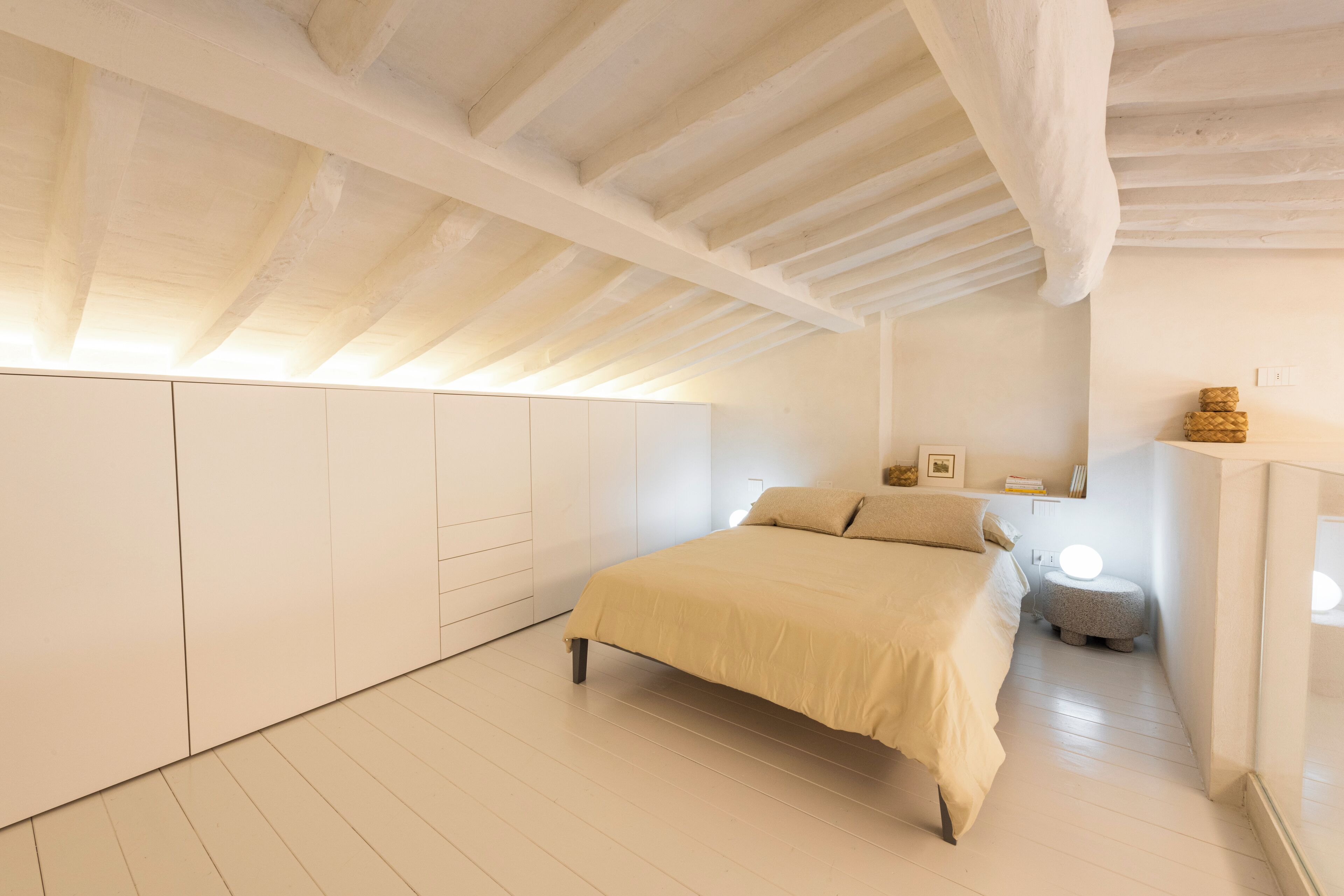 Ein Schlafzimmer mit Bett, Einbauschrank und einem kleinen Nachttisch.