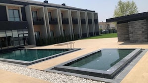 En modern byggnad med en swimmingpool, utomhusmöbler och ett välanlagt område.
