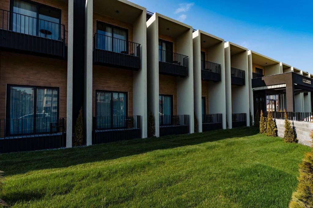 A modern multi-story hotel with balconies and large windows.