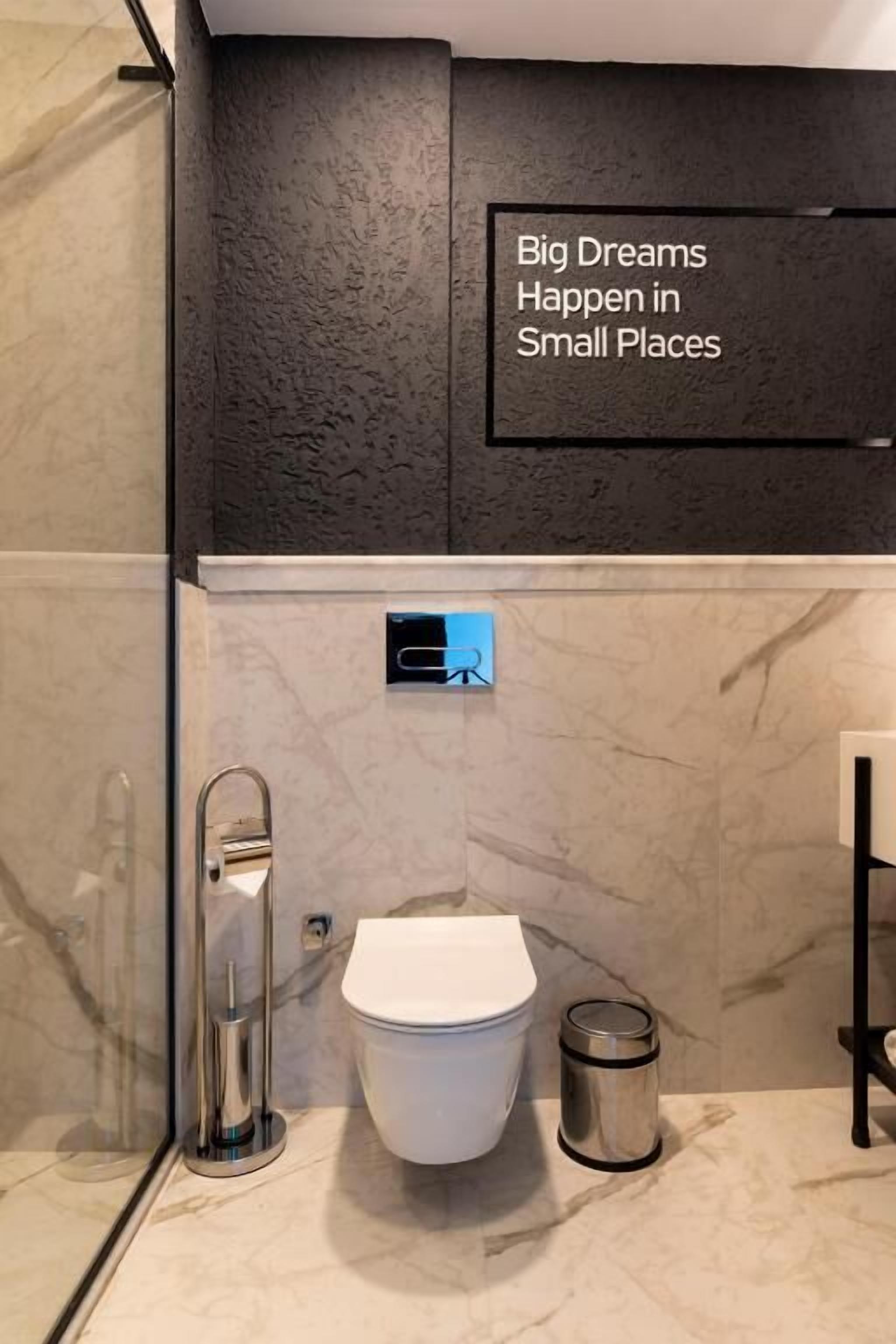 Un baño moderno con inodoro, bidé y un cubo de basura.