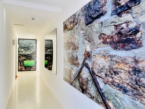Ein Flur mit einer Steinwand und zwei gerahmten Bildern einer felsigen Landschaft.