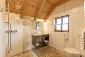 A bathroom with a shower, sink, and toilet.