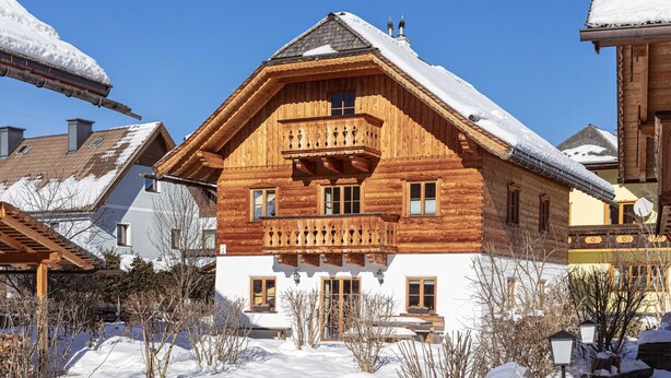 A wooden chalet with a balcony, surrounded by snow-covered trees and other buildings. - AlpiNest Hochgolling 2 Loft Apartment (Mariapfarr)