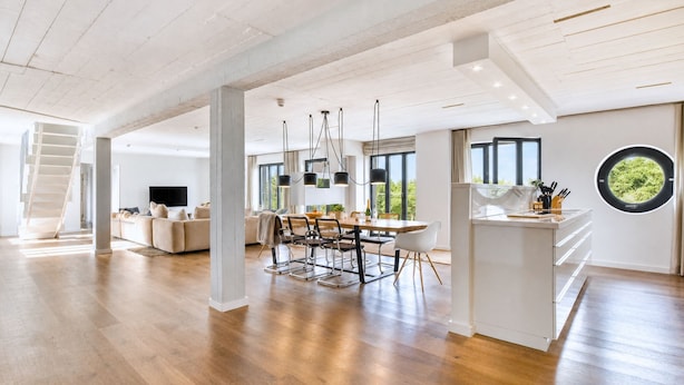 Amplia sala de estar con mesa de comedor, sofás y una isla de cocina.