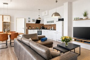 A modern living space with a sofa, coffee table, and a flat-screen TV.