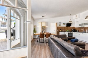 A modern interior with a dining area, kitchen, and seating space.