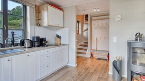 A modern kitchen with white cabinets, a coffee maker, and a stove. - Newly built, modern, exclusive - that describes the Klein Stresow vacation village (Klein Stresow)