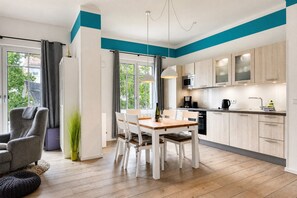 A modern kitchen with wooden cabinets, a dining table, and chairs. - Home port: Your Baltic Sea retreat at Villa Sofie Binz - with roof terrace (Binz)