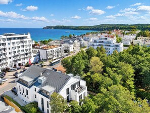 A coastal town with modern buildings, a marina, and a view of the sea.