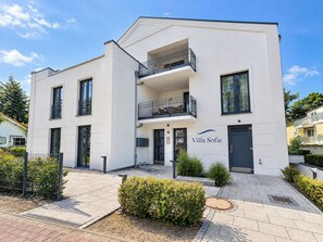 Un immeuble moderne à deux étages, doté d’un balcon, d’une porte portant le numéro 9 et d’une enseigne indiquant « Villa Sofie ».
