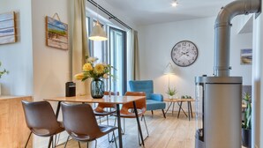 Una cocina moderna con una mesa de madera, sillas, una estufa y un reloj en la pared.