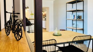 Uma sala de jantar moderna com uma mesa de madeira, cadeiras pretas e uma bicicleta em primeiro plano.