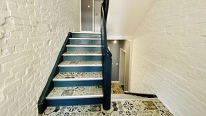 Una escalera con paredes de ladrillo blanco y escalones azules.
