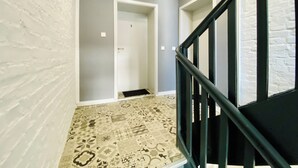 A staircase with a patterned floor leading to a door marked with the number 6.