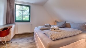 Un dormitorio con una cama, un escritorio y una silla.