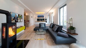 A modern living room with a fireplace, a sofa, and a glass coffee table. - "My time out": Luxurious wellness suite with pool, sauna & infrared cabin (Binz)
