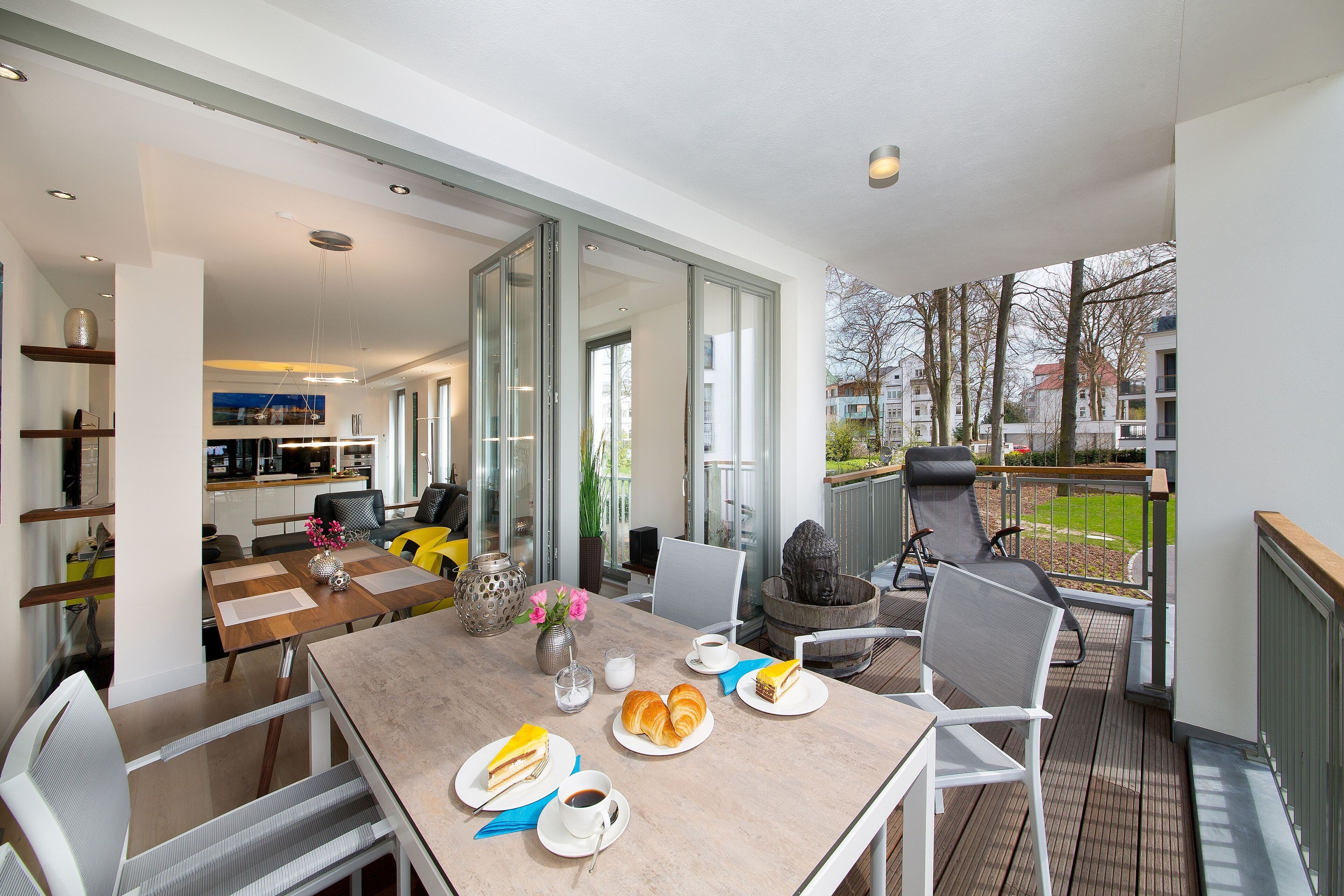Ett modernt matområde med ett bord för två personer, en soffa och utsikt över balkongen.