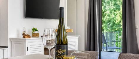 Ett matbord med en flaska Rieslingvin, ett vinglas och en burk Bienenkönig på en servett.