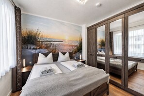 Un dormitorio con una cama grande, un espejo y un mural decorativo con un paisaje.