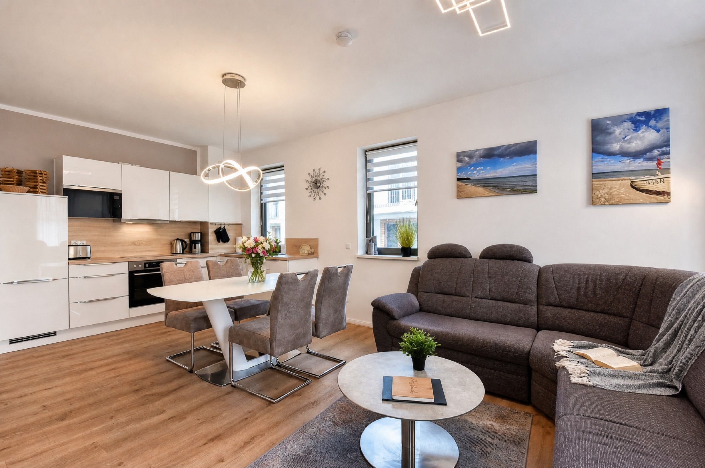 A modern living space with a kitchen, dining area, and seating area.