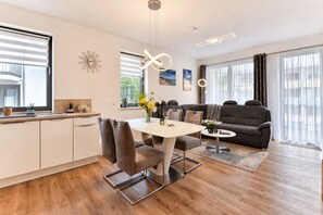 Un espacio habitable moderno con comedor, sofá y cocina.