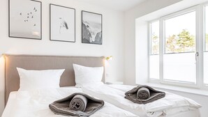 A hotel room with two beds, white bedding, and three framed pictures on the wall. - Sunshine by the sea: a modern oasis for unforgettable moments in Prora, Rügen (Prora)