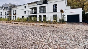 A modern two-story building with a flat roof, multiple balconies, and a garage. - Charming "Meereslauschen" vacation apartment in Villa Beatrice: luxury, comfort (Binz)