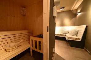 Una sauna con bancos de madera y un pequeño armario de madera.