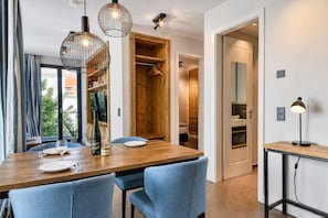 Un comedor moderno con mesa de madera, sillas azules e iluminación colgante.