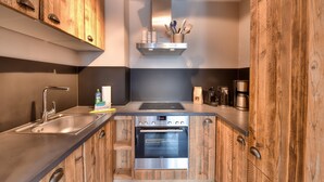 Une cuisine moderne avec des meubles en bois, des appareils électroménagers en acier inoxydable et un four encastré.