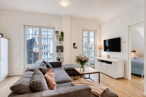 Un apartamento moderno con sala de estar, kitchenette y un dormitorio.