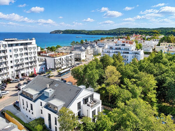 En kuststad med moderna byggnader, en småbåtshamn och utsikt över havet.