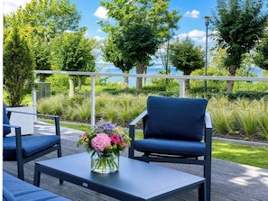 An outdoor seating area with a table, chairs, and a vase of flowers. - "Küstenblick" Luxury Vacation Apartment at Villa Claire on the Beach in Sellin (Sellin)